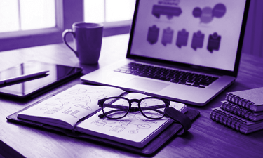 glasses on a book in front of a computer